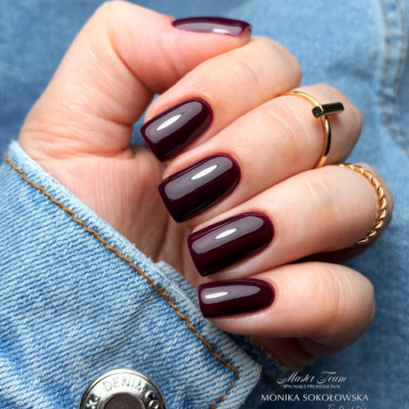 Manicured nails painted with SPN Nails UV/LED Gel Polish 935 Plum Boom, showcasing a glossy plum finish.