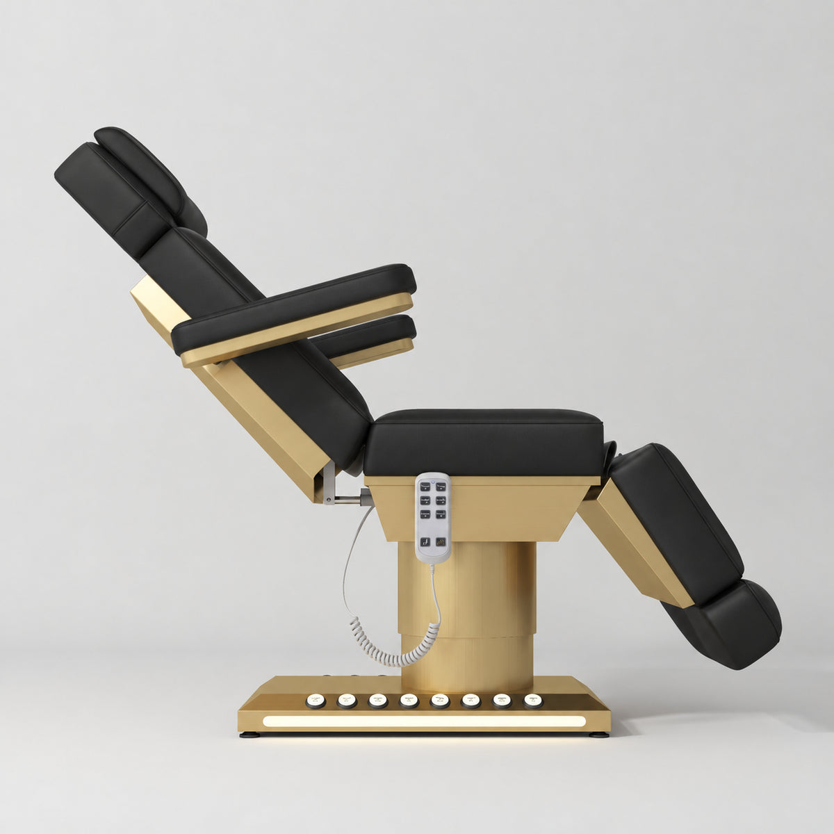 Manufakturo Aurélie beauty bed in Black with gold-finished base, side view with backrest raised and leg section lowered.