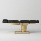 Manufakturo Aurélie beauty bed in Black with gold-finished base, flat side view.