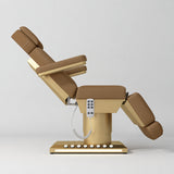 Manufakturo Aurélie beauty bed in Caramel with gold-finished base, side view with backrest raised and leg section lowered.