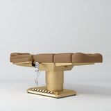Manufakturo Aurélie beauty bed in Caramel with gold-finished base, flat low-angle view.