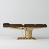 Manufakturo Aurélie beauty bed in Cocoa Mocha with gold-finished base, flat side view.