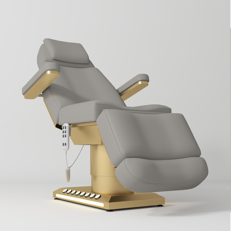 Manufakturo Aurélie beauty bed in Pearl Greige with gold-finished base, reclined front three-quarter view.
