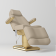 Manufakturo Aurélie beauty bed in Warm Beige with gold-finished base, reclined front three-quarter view.