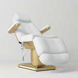 Manufakturo Aurélie beauty bed in White with gold-finished base, reclined front three-quarter view.