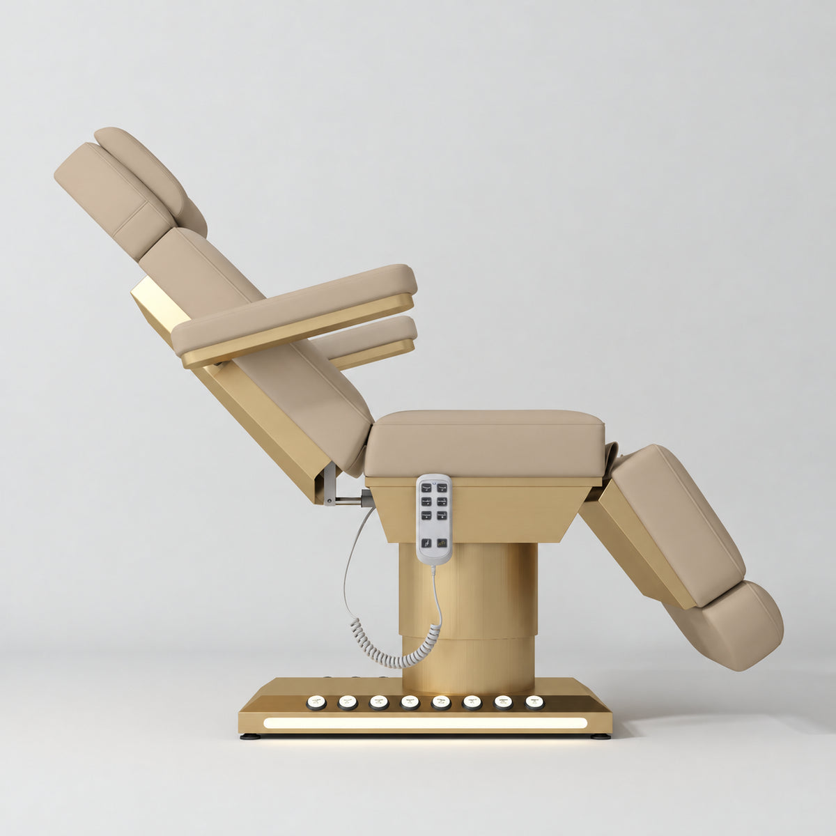 Manufakturo Aurélie beauty bed in Warm Beige with gold-finished base, side view with backrest raised and leg section lowered.