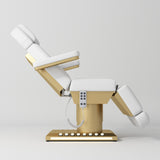 Manufakturo Aurélie beauty bed in White with gold-finished base, side view with backrest raised and leg section lowered.