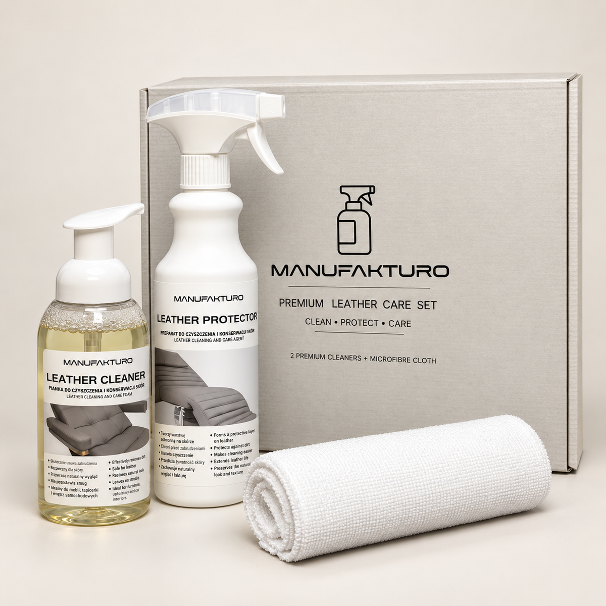 Manufakturo premium leather care set including a leather cleaner pump bottle, a leather protector spray bottle, a rolled white microfiber cloth, and a gray presentation box on a light beige background.