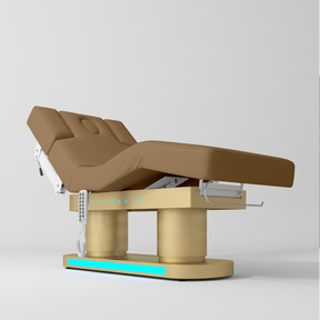 An electric medical examination table with a brown padded examination bed on a beige metal frame, shown against a light gray studio background.