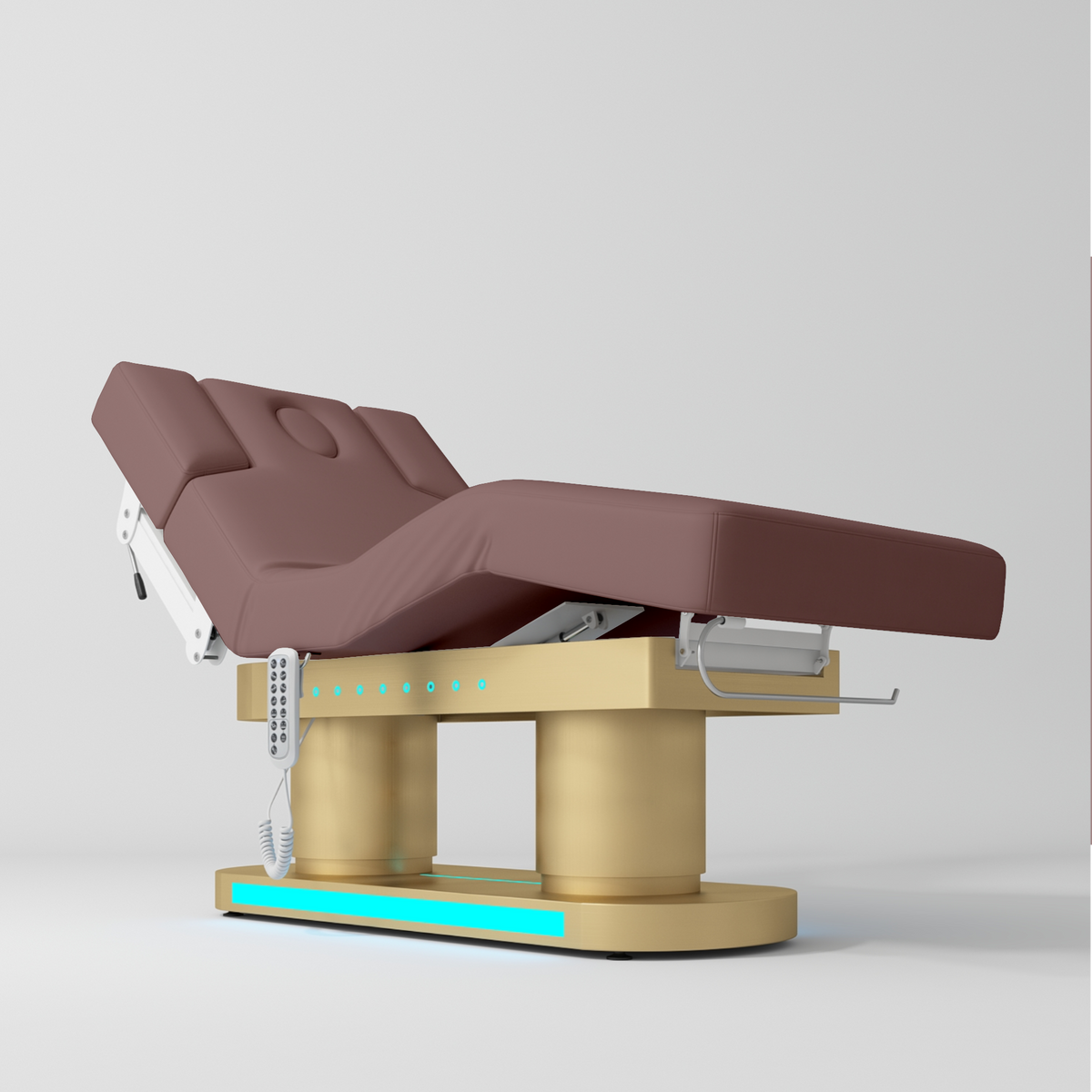 An adjustable medical or spa treatment table with a dusty rose pink padded bed frame and a gold base, shown on a light gray studio background.