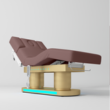 An adjustable medical or spa treatment table with a dusty rose pink padded bed frame and a gold base, shown on a light gray studio background.