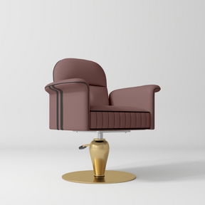 A modern barber-style swivel chair with dusty-rose-colored leather upholstery, black piping details, and a polished gold metal base, shown on a light gray studio background.