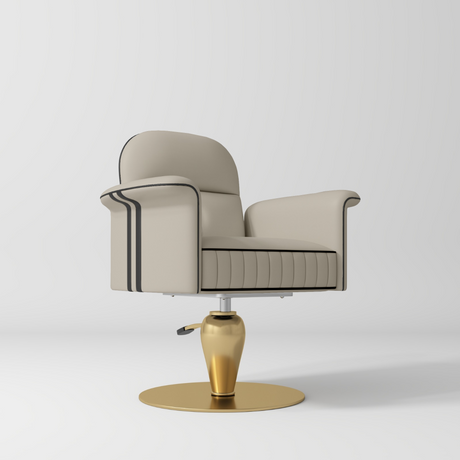 A modern barber-style swivel chair with cream-colored leather upholstery, black piping details, and a polished gold metal base, shown on a light gray studio background.
