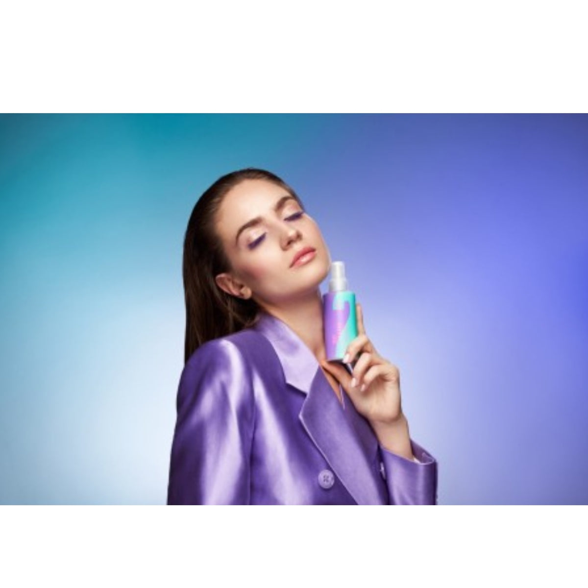 Model holding OnlyBio Hair Cycling Hydration Kit HCH01 serum bottle, wearing a purple satin blazer against a gradient blue background. Vegan and moisturizing hair care set for healthy, hydrated hair.