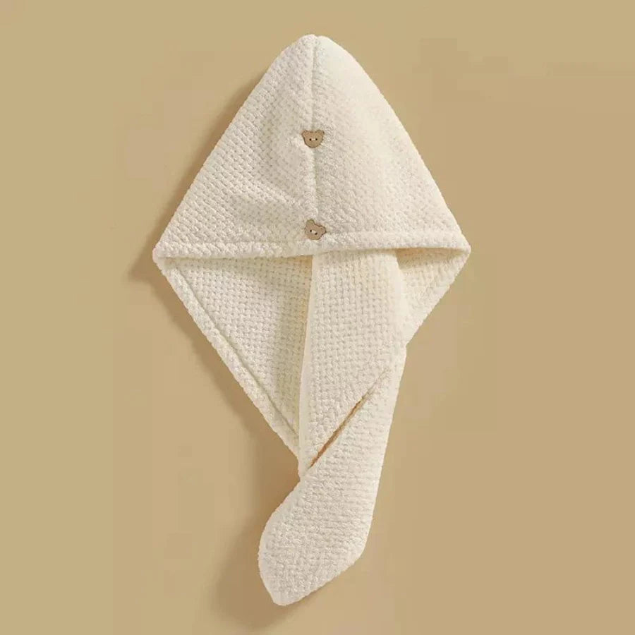 Beige microfiber hair towel with a button closure, designed for quick drying and gentle care of high porosity hair.