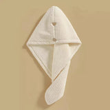 Beige microfiber hair towel with a button closure, designed for quick drying and gentle care of high porosity hair.