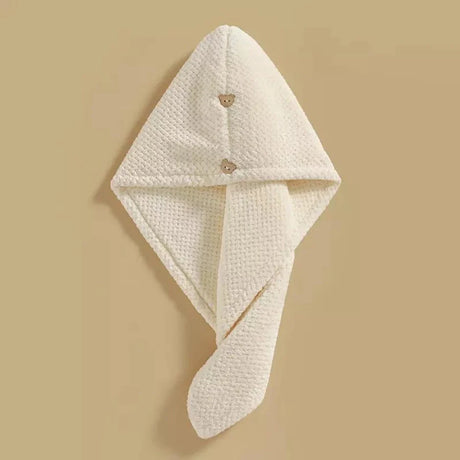 Beige microfiber hair towel with a button closure, designed for quick drying and gentle care of high porosity hair.