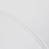 Close-up of the snow-white faux leather upholstery and stitching