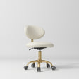 Manufakturo Aura Gold Legs Beauty Stool Creamy - displayed in a professional treatment-room setting