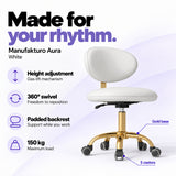 Manufakturo Aura White beauty stool with gas-lift height adjustment, 360-degree swivel, padded backrest, gold five-spoke base, five castors and 150 kg maximum load.
