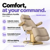 Manufakturo Aurélie Warm Beige electric beauty bed with 3 motors, hand and integrated foot controls, extendable footrest, adjustable headrest and LED base lighting.