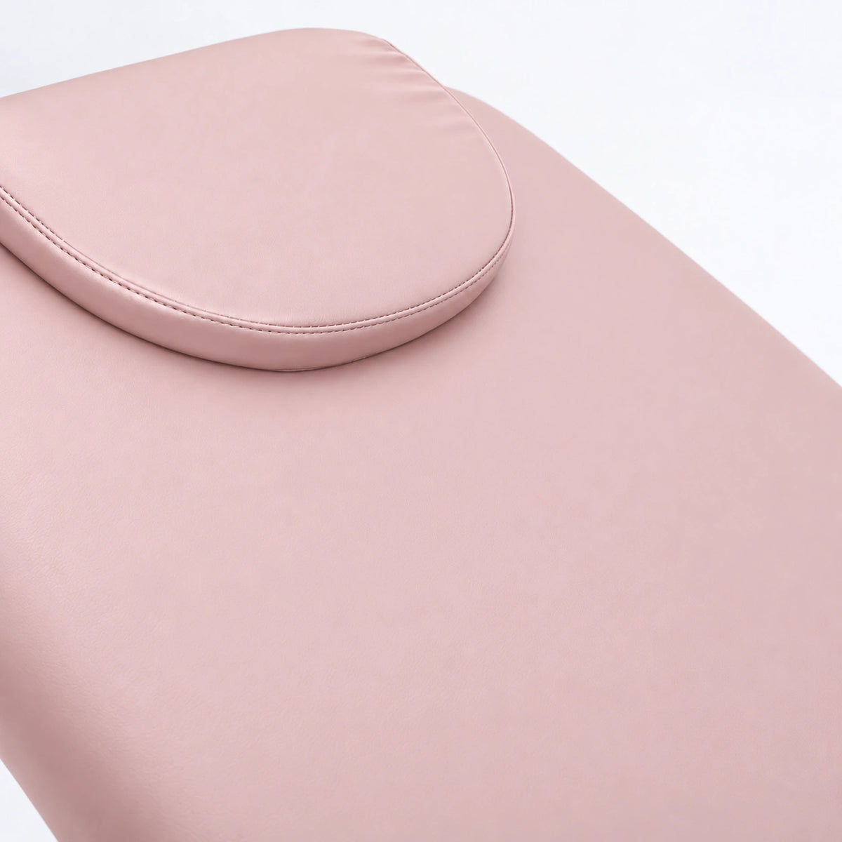 Manufakturo Chérie Bare Blush electric massage bed — close-up of the removable headrest pillow and upholstery.