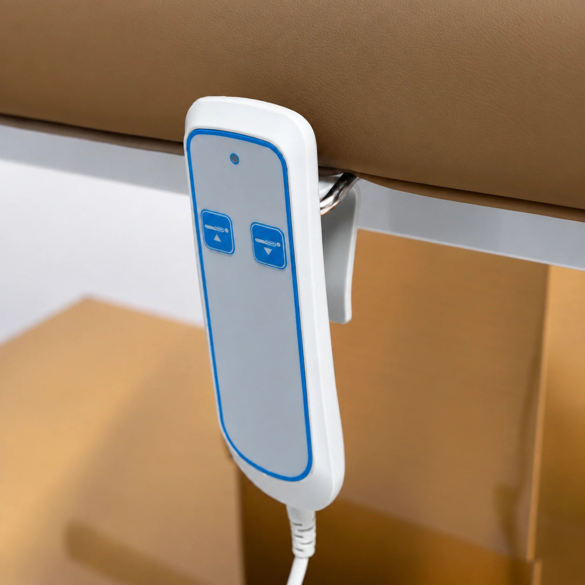 Manufakturo Chérie Caramel electric massage bed — close-up of the two-button hand-held height control and upholstery.