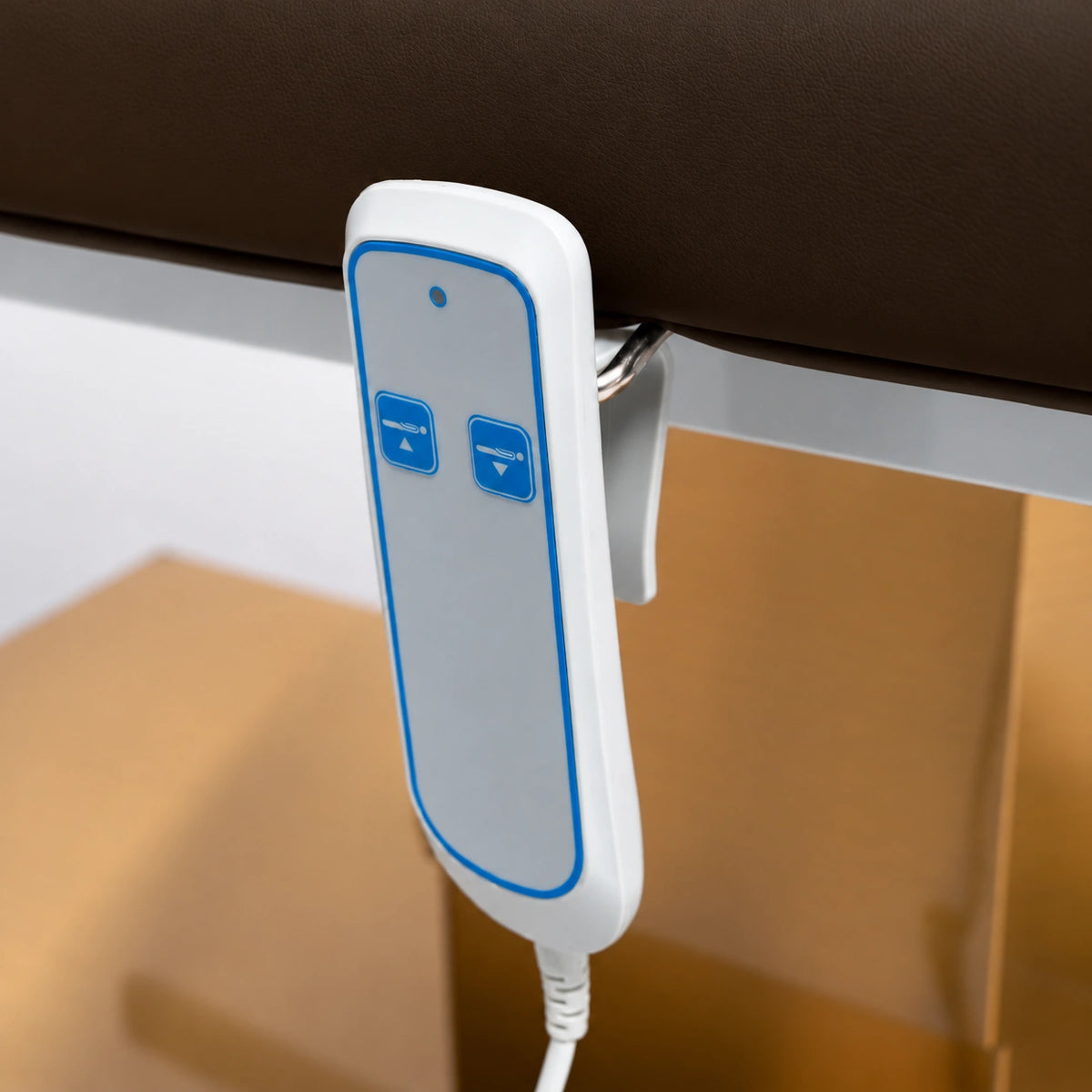 Manufakturo Chérie Cocoa Mocha electric massage bed — close-up of the two-button hand-held height control and upholstery.