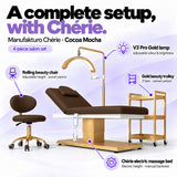 Manufakturo Chérie Cocoa Mocha salon set features: electric bed height and manual backrest adjustment, height-adjustable rolling chair, V3 Pro Gold lamp with adjustable colour and brightness, and three-tier gold trolley.
