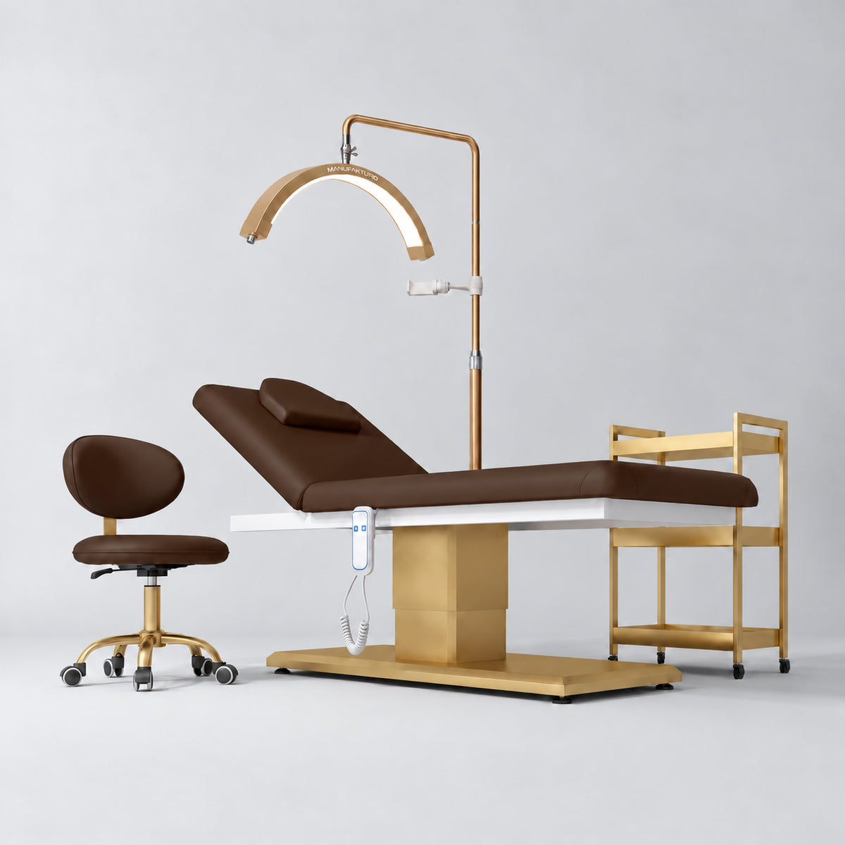 Manufakturo Chérie Cocoa Mocha four-piece salon set with electric massage bed, matching rolling beauty chair, V3 Pro Gold treatment lamp and empty three-tier gold trolley.