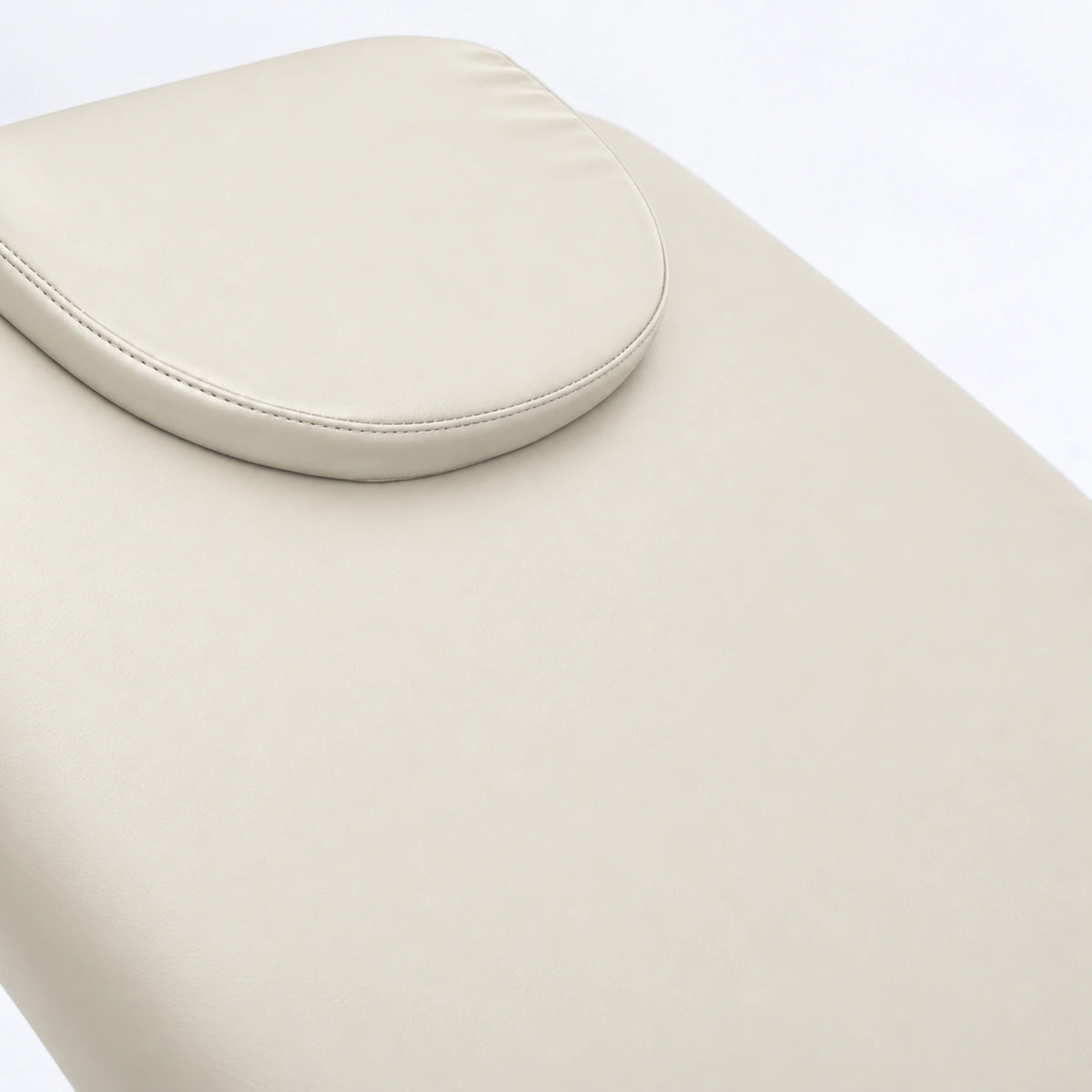 Manufakturo Chérie Creamy electric massage bed — close-up of the removable headrest pillow and upholstery.