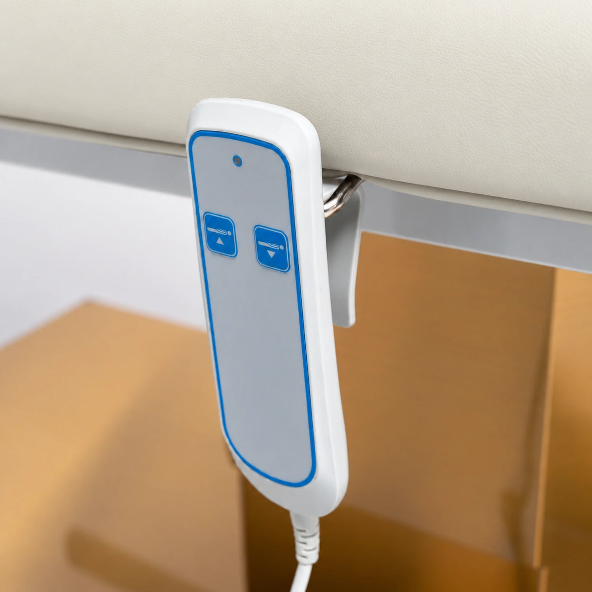 Manufakturo Chérie Creamy electric massage bed — close-up of the two-button hand-held height control and upholstery.