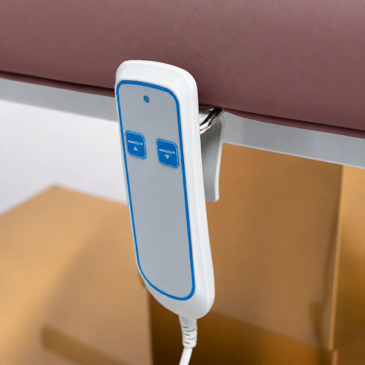 Manufakturo Chérie Dusty Rose electric massage bed — close-up of the two-button hand-held height control and upholstery.
