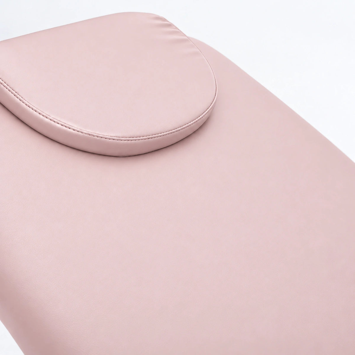 Manufakturo Chérie Light Pink electric massage bed — close-up of the removable headrest pillow and upholstery.