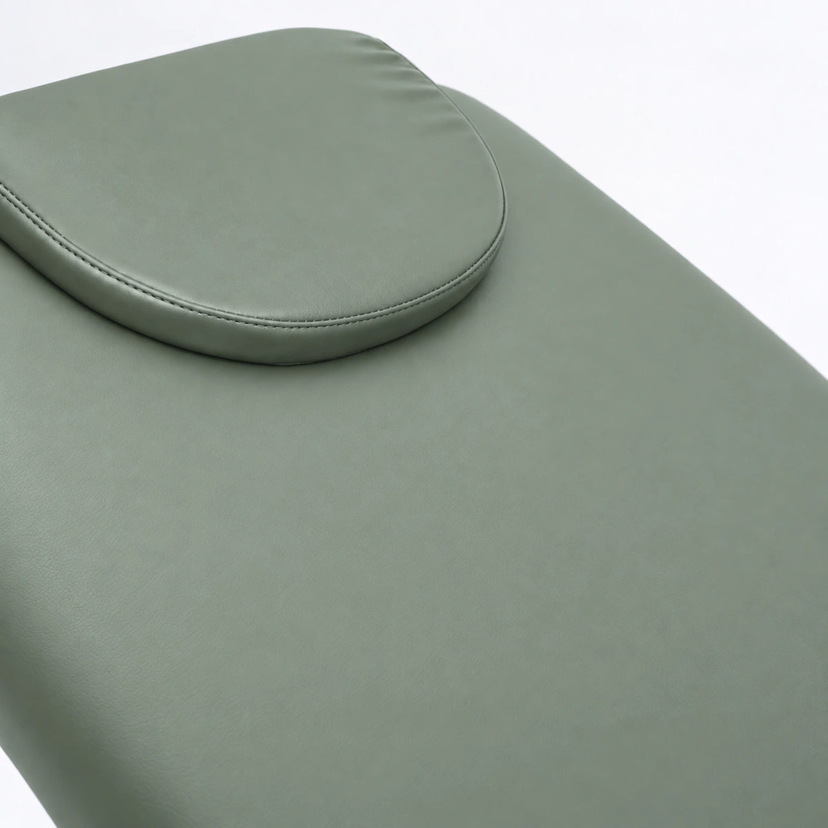 Manufakturo Chérie Olive electric massage bed — close-up of the removable headrest pillow and upholstery.