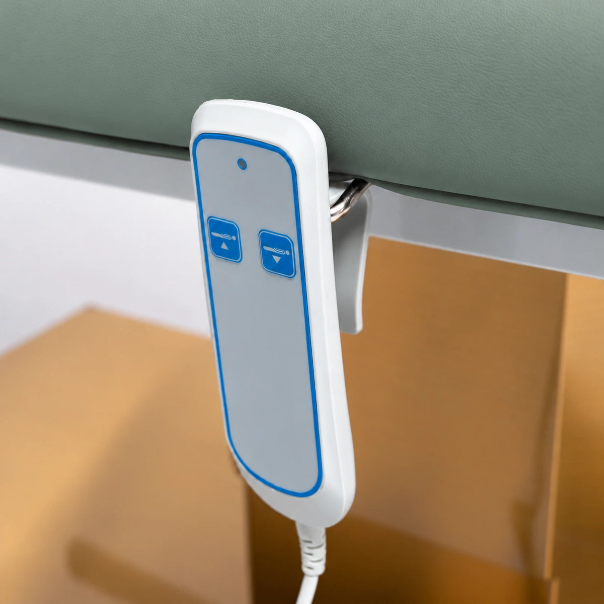 Manufakturo Chérie Olive electric massage bed — close-up of the two-button hand-held height control and upholstery.