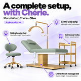 Manufakturo Chérie Olive salon set features: electric bed height and manual backrest adjustment, height-adjustable rolling chair, V3 Pro Gold lamp with adjustable colour and brightness, and three-tier gold trolley.