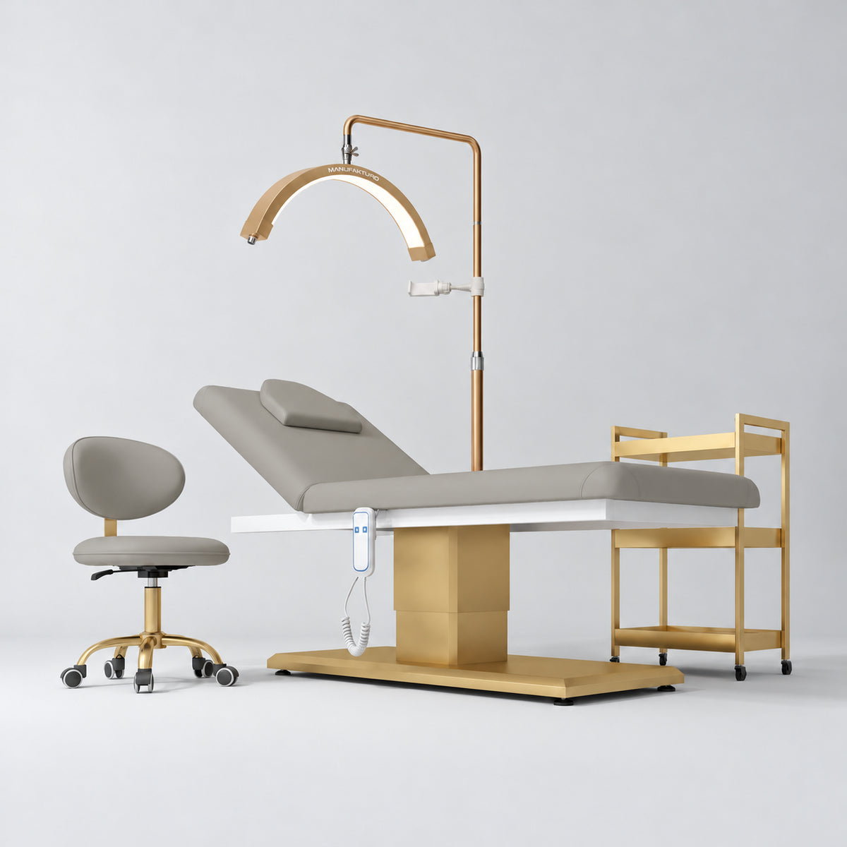 Manufakturo Chérie Pearl Greige four-piece salon set with electric massage bed, matching rolling beauty chair, V3 Pro Gold treatment lamp and empty three-tier gold trolley.