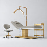 Manufakturo Chérie Pearl Greige four-piece salon set with electric massage bed, matching rolling beauty chair, V3 Pro Gold treatment lamp and empty three-tier gold trolley.