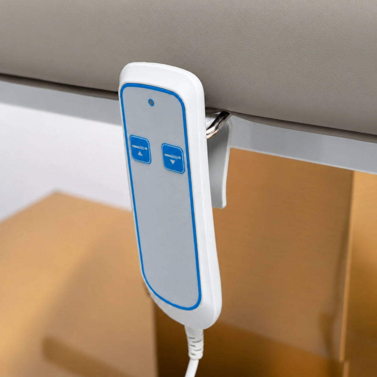 Manufakturo Chérie Stone Taupe electric massage bed — close-up of the two-button hand-held height control and upholstery.