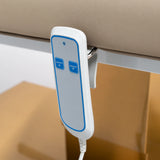 Manufakturo Chérie Warm Beige electric massage bed — close-up of the two-button hand-held height control and upholstery.