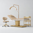 Manufakturo Chérie Warm Beige four-piece salon set with electric massage bed, matching rolling beauty chair, V3 Pro Gold treatment lamp and empty three-tier gold trolley.