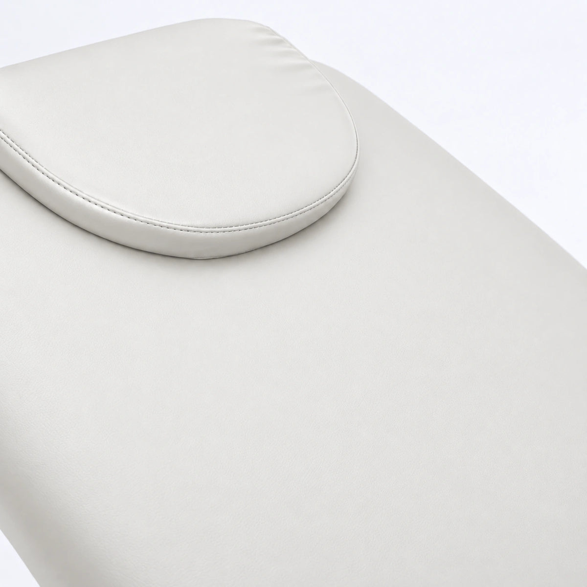 Manufakturo Chérie White electric massage bed — close-up of the removable headrest pillow and upholstery.