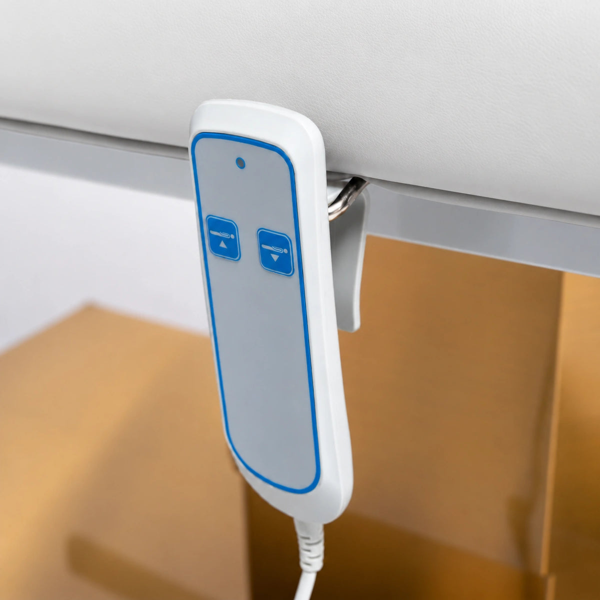 Manufakturo Chérie White electric massage bed — close-up of the two-button hand-held height control and upholstery.