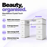 Manufakturo Crystal Touch White manicure table with built-in dust extractor, eight storage drawers, an open shelf and a 12 mm sintered stone worktop.