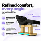 Manufakturo Divina electric spa treatment bed in Black, showing four electric motors, a 15 cm heated mattress, integrated LED lighting, face opening, adjustable armrests and twin-column base.