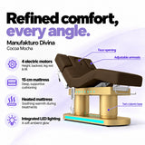 Manufakturo Divina electric spa treatment bed in Cocoa Mocha, showing four electric motors, a 15 cm heated mattress, integrated LED lighting, face opening, adjustable armrests and twin-column base.