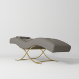Manufakturo Elegance Lash Bed - Gold Frame & Adjustable Headrest Deep Ash - displayed in a professional treatment-room setting