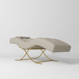 Manufakturo Elegance Lash Bed - Gold Frame & Adjustable Headrest Stone Taupe - displayed in a professional treatment-room setting