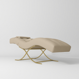 Manufakturo Elegance Lash Bed - Gold Frame & Adjustable Headrest Warm Beige - displayed in a professional treatment-room setting